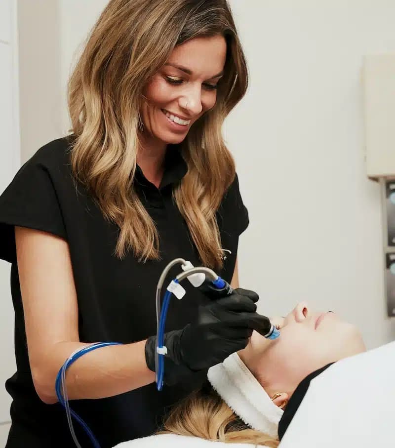 woman receiving hydrafacial treatment at awskinco